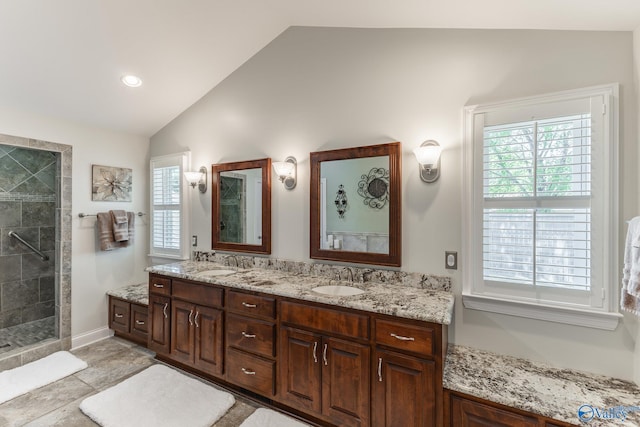 406 Zandale Dr SW, Huntsville, AL 35801 - bathroom with lofted ceiling, tiled shower, and double vanity