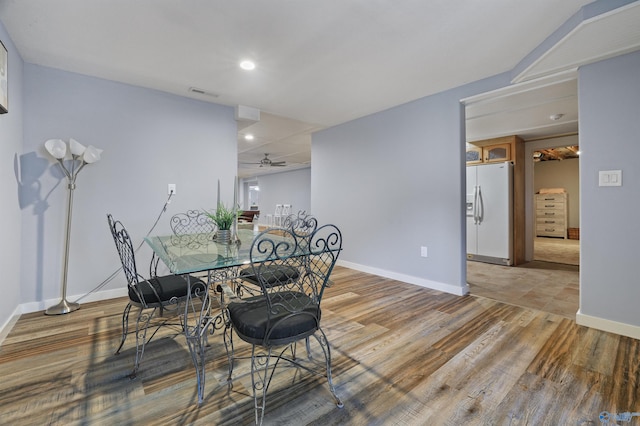 dining area with wood-type flooring and ceiling fan