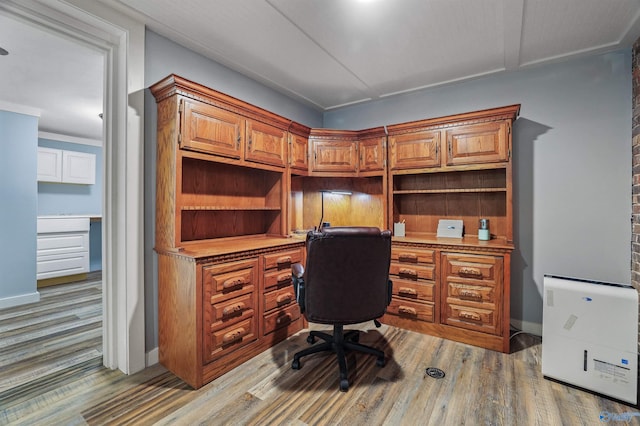 office space with wood-type flooring and built in desk