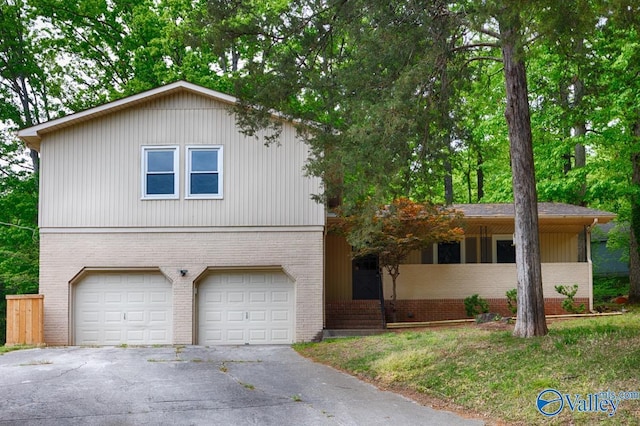 view of front of home with brick siding, a garage, and aphalt driveway