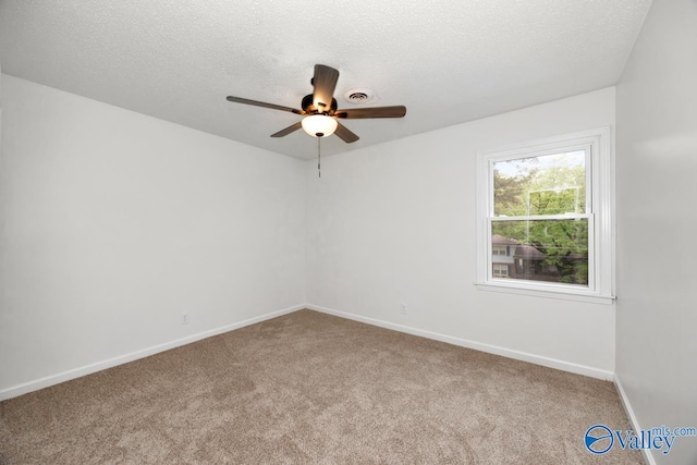 carpeted spare room featuring a textured ceiling, baseboards, and ceiling fan