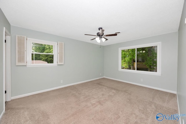 carpeted empty room with baseboards and ceiling fan
