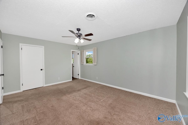 unfurnished bedroom with baseboards, a textured ceiling, visible vents, and carpet