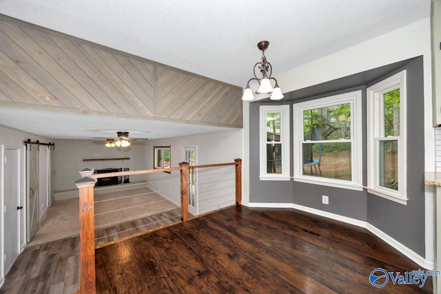 interior space with baseboards, wood finished floors, and a barn door