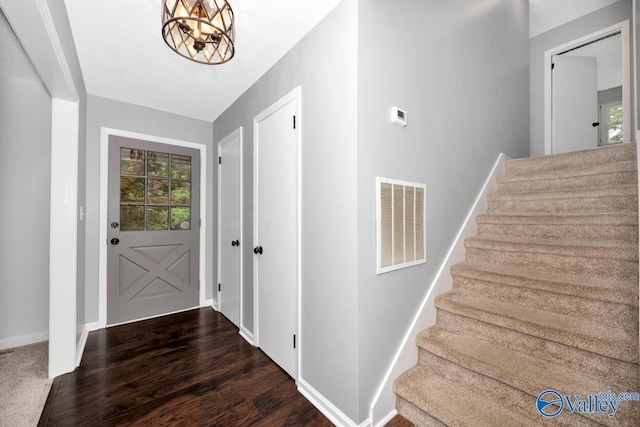entryway with dark wood-style floors, stairs, visible vents, and plenty of natural light