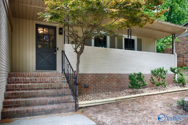 property entrance featuring brick siding