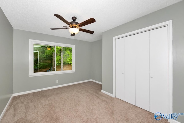 unfurnished bedroom featuring a ceiling fan, baseboards, carpet floors, and a closet