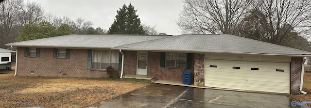 ranch-style home featuring a garage, brick siding, and driveway