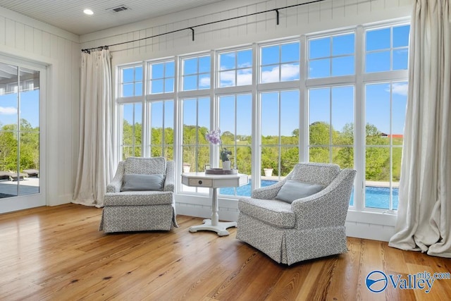 sitting room with plenty of natural light, visible vents, and wood-type flooring