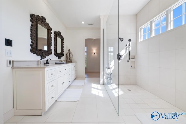 full bath featuring double vanity, tile patterned floors, visible vents, and a walk in shower