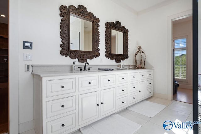 bathroom with a sink, double vanity, and tile patterned floors