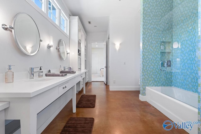 bathroom with a sink, double vanity, concrete flooring, and baseboards