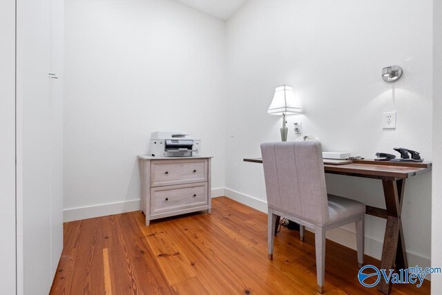 office space featuring baseboards and light wood-type flooring