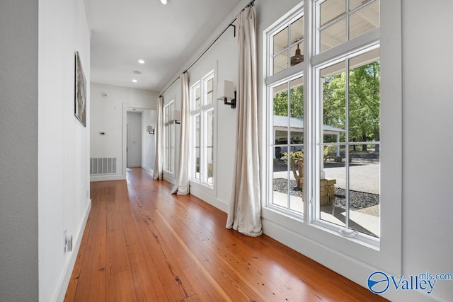 hallway with baseboards, recessed lighting, light wood finished floors, and visible vents