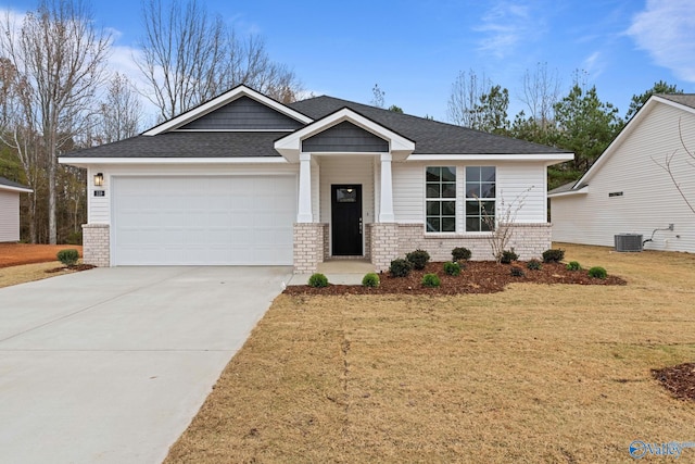 view of front of house with a garage, cooling unit, and a front lawn