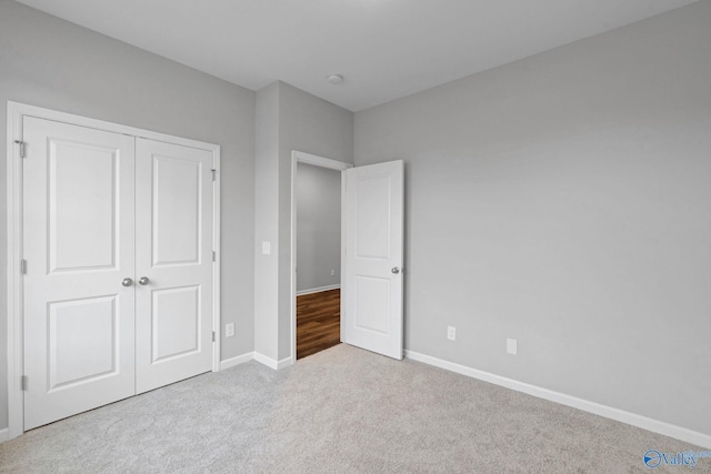 unfurnished bedroom featuring light carpet and a closet