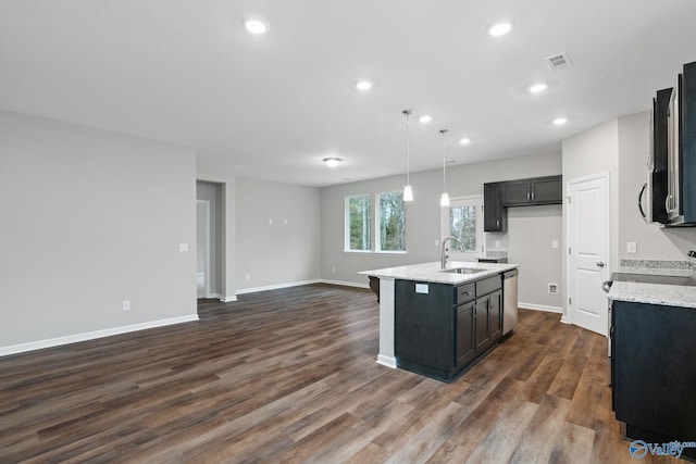 kitchen with stainless steel dishwasher, decorative light fixtures, sink, dark wood-type flooring, and a kitchen island with sink