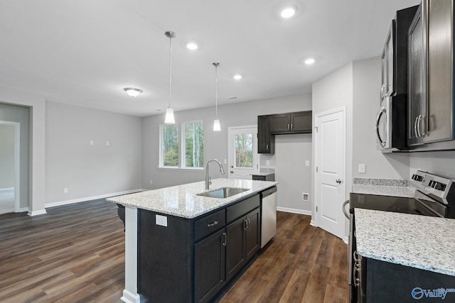 kitchen featuring appliances with stainless steel finishes, sink, dark hardwood / wood-style flooring, and a center island with sink