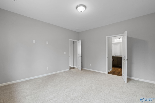 unfurnished bedroom featuring carpet and ensuite bathroom