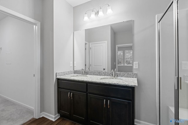 bathroom featuring walk in shower, double sink vanity, and hardwood / wood-style floors