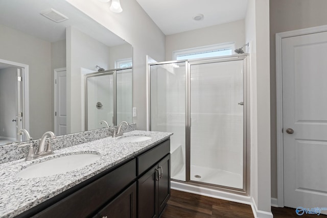 bathroom featuring double vanity, walk in shower, and hardwood / wood-style flooring