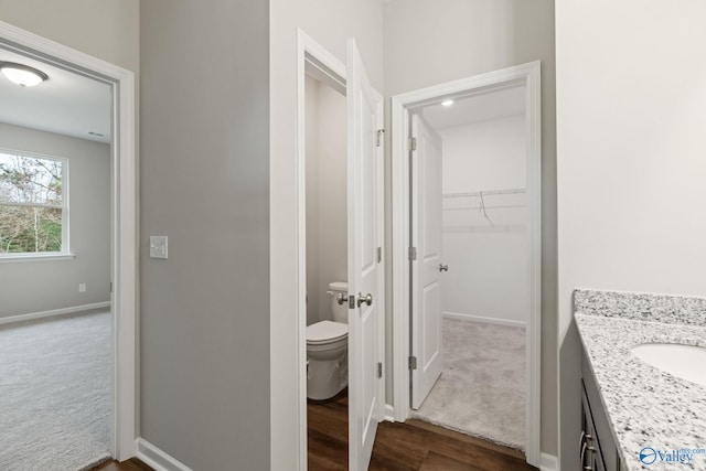 bathroom featuring vanity, toilet, and hardwood / wood-style floors