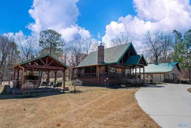 exterior space with a gazebo, a patio, a front lawn, and a chimney