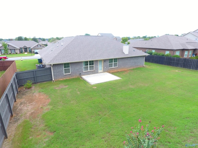 rear view of property with a yard and a patio