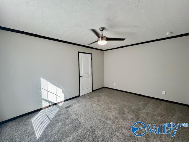 unfurnished room with carpet floors, a textured ceiling, and ornamental molding