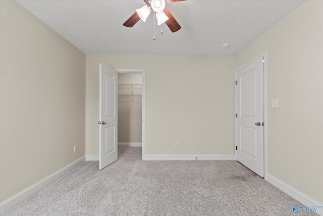 unfurnished bedroom featuring ceiling fan, light colored carpet, and a textured ceiling