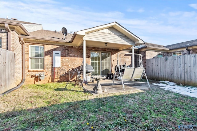 rear view of property with a patio and a lawn