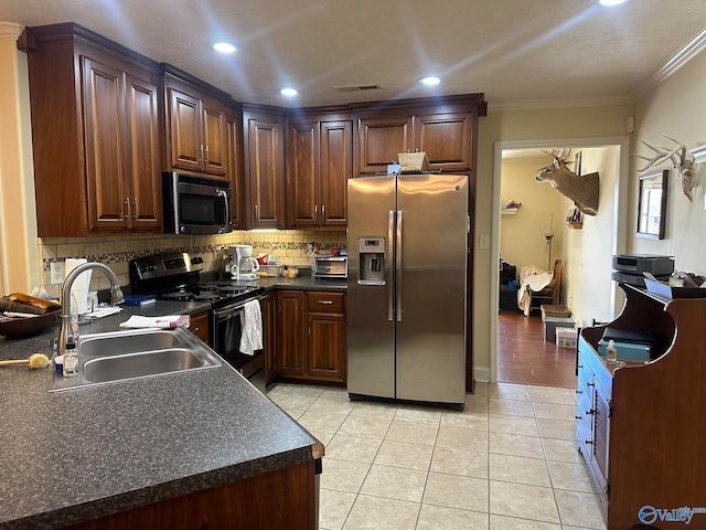 kitchen with stainless steel appliances, tasteful backsplash, ornamental molding, light tile patterned flooring, and sink