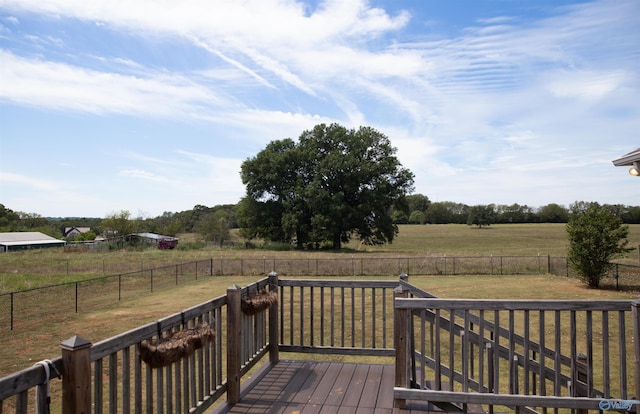 wooden terrace featuring a fenced backyard, a lawn, and a rural view