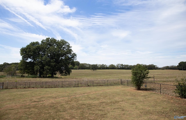 view of yard featuring fence and a rural view