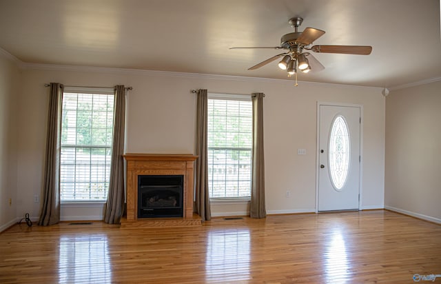 foyer featuring crown molding, plenty of natural light, and light wood finished floors