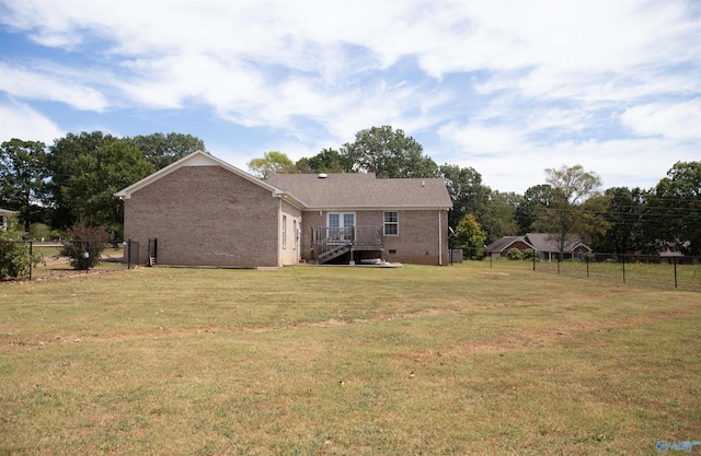 back of property with brick siding, crawl space, fence, and a lawn