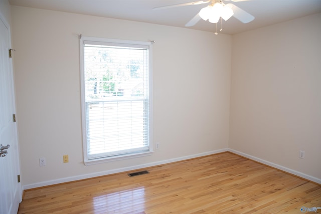 unfurnished room with light wood finished floors, plenty of natural light, visible vents, and a ceiling fan