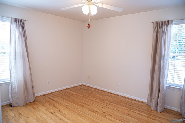 empty room with light wood-style flooring, baseboards, and a ceiling fan