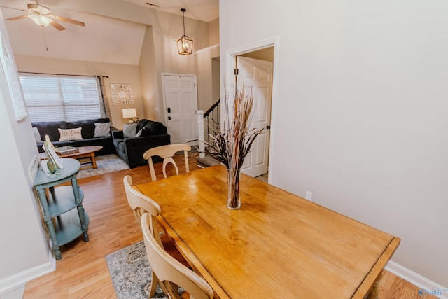 dining space featuring ceiling fan, lofted ceiling, and light hardwood / wood-style flooring