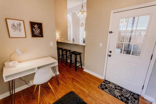 foyer with wood-type flooring, sink, and a notable chandelier