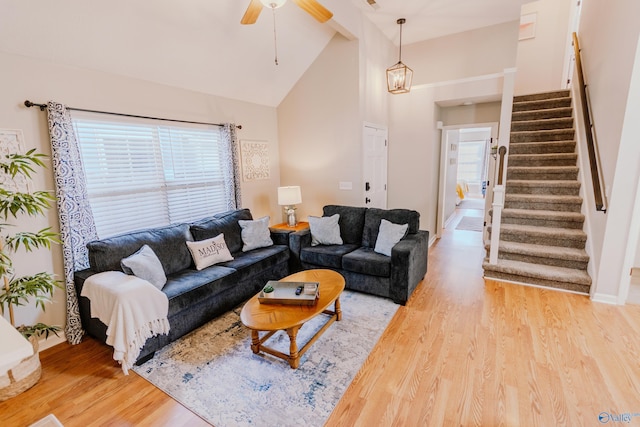 living room featuring high vaulted ceiling, ceiling fan, and light wood-type flooring