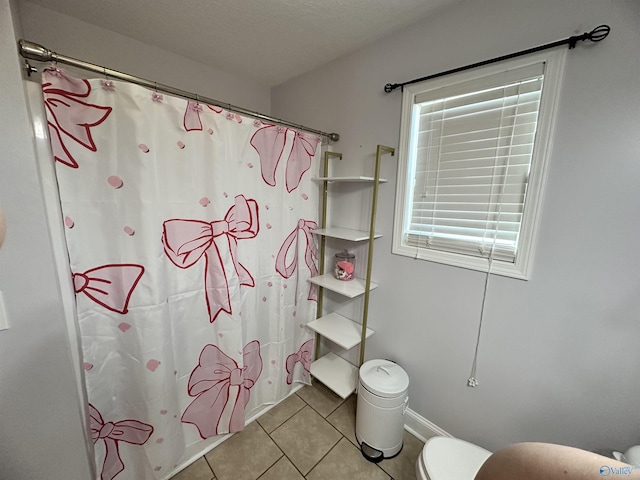 bathroom featuring toilet, tile patterned flooring, and shower / bath combo with shower curtain