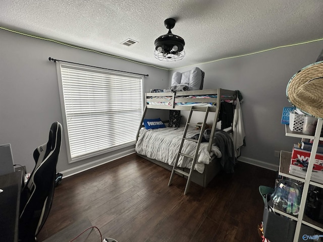 bedroom with dark wood-type flooring, multiple windows, and a textured ceiling