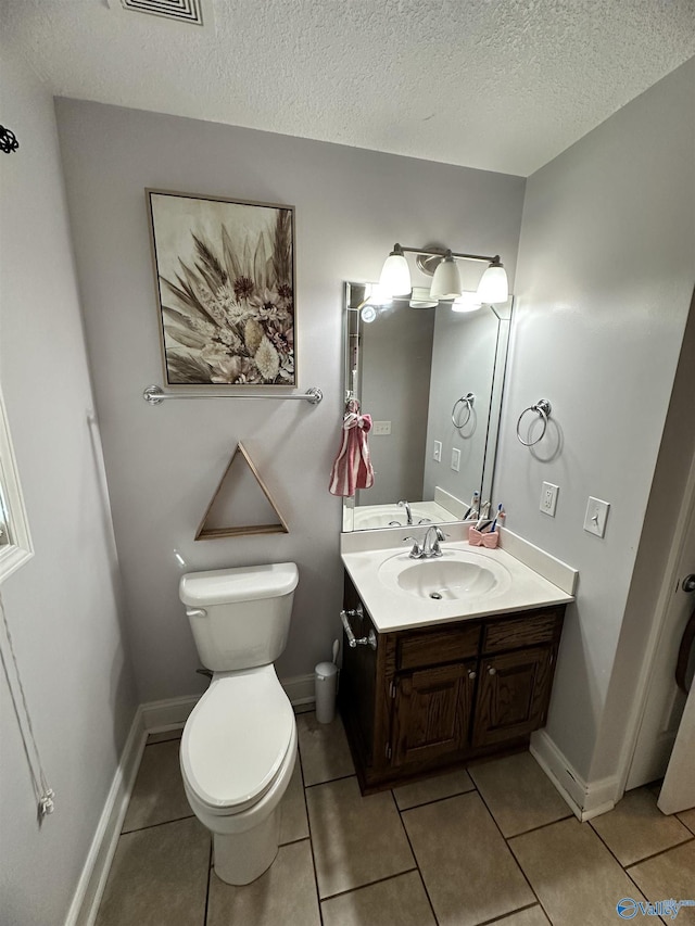 bathroom featuring a textured ceiling, tile patterned floors, vanity, and toilet