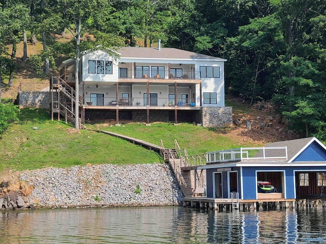 back of house featuring a yard, a balcony, and a water view