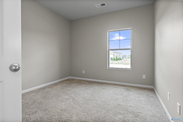 carpeted spare room featuring baseboards and visible vents