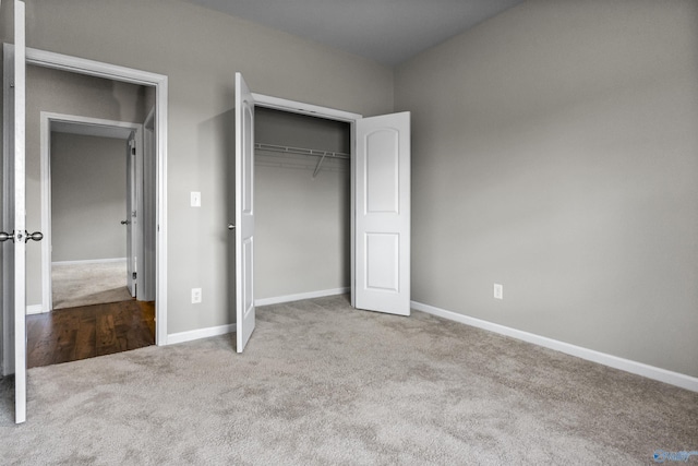 unfurnished bedroom with carpet flooring, baseboards, and a closet