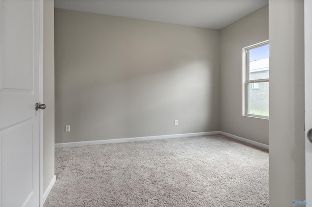 carpeted spare room featuring baseboards