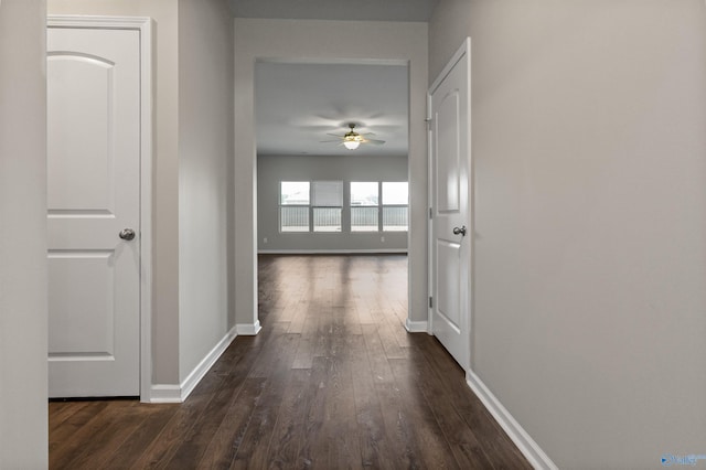 hall featuring baseboards and dark wood finished floors