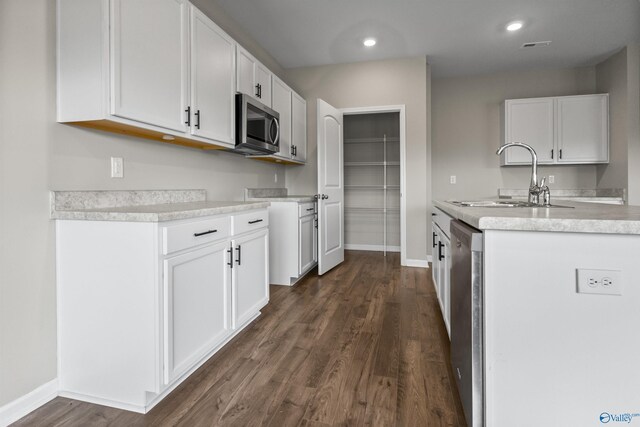 kitchen featuring appliances with stainless steel finishes, dark hardwood / wood-style flooring, white cabinets, and sink